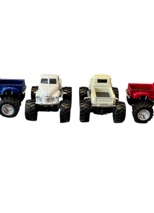 Four Chevy pickup monster truck toys in the colors blue, white, beige and red. The blue, beige and red trucks are positioned to show the truck bed. 