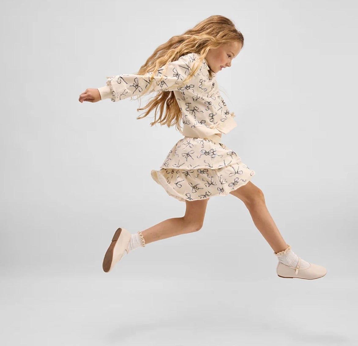 Model Wearing Miles The Label Bow Locket Sweatshirt & Skirt Set