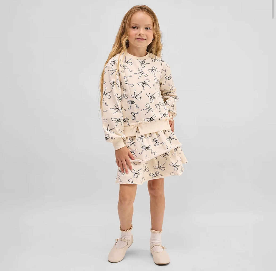 Model Wearing Miles The Label Bow Locket Sweatshirt & Skirt Set