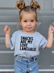 Model Wearing Little Threads Co. Snacks Are My Love Language Toddler T-Shirt