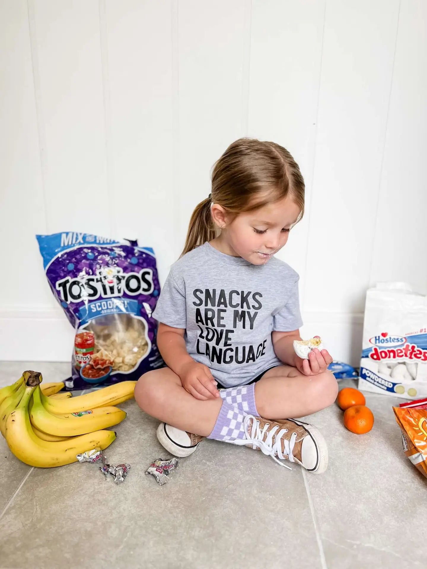 Model Wearing Little Threads Co. Snacks Are My Love Language Toddler T-Shirt