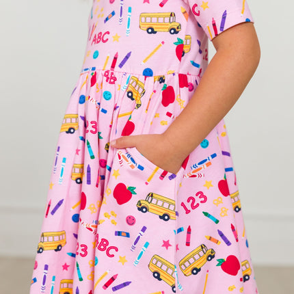 Model Wearing Rufflebutts + Ruggedbutts Girls Pink School House Short Sleeve Knit Twirl Dress