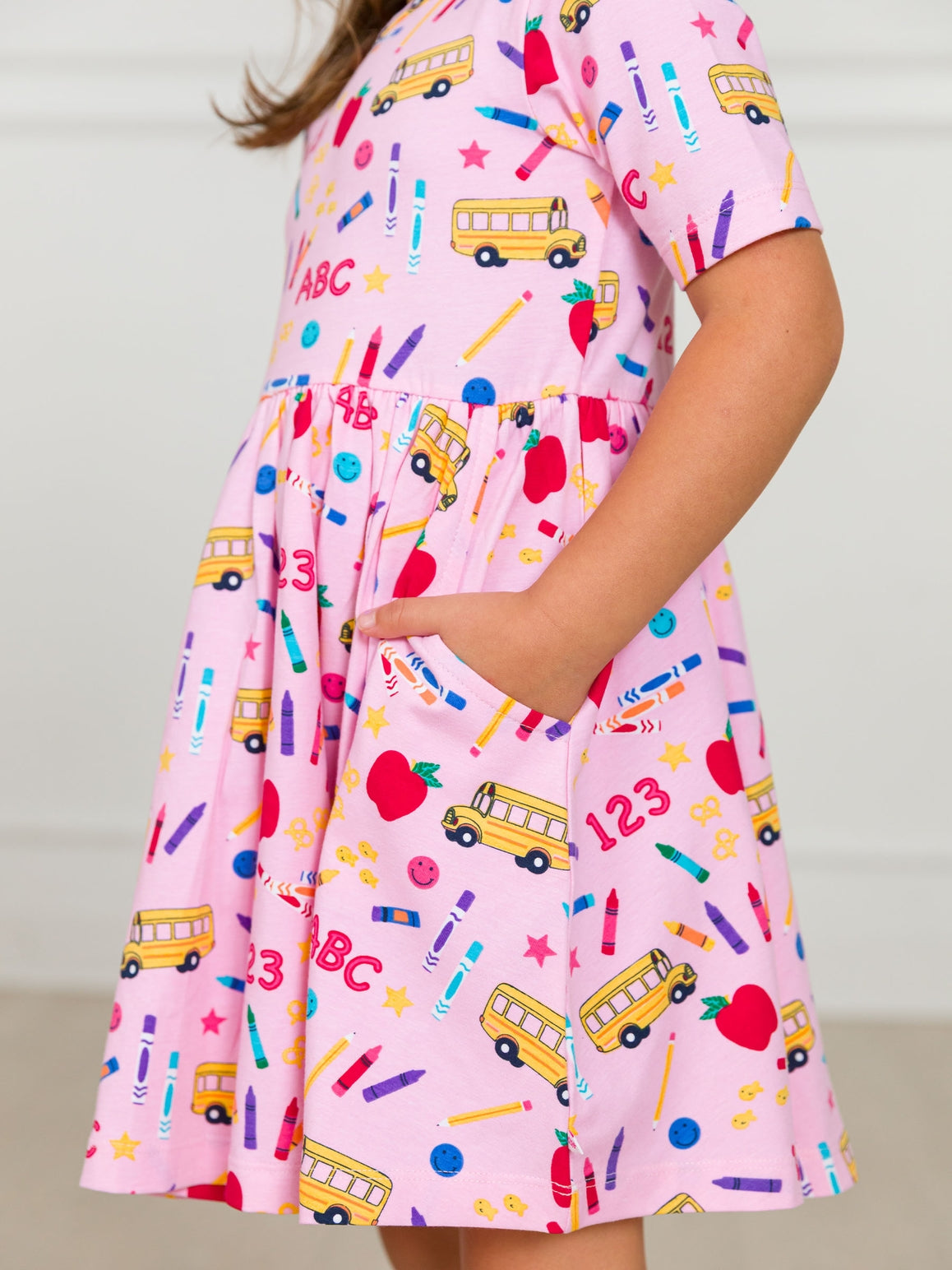 Model Wearing Rufflebutts + Ruggedbutts Girls Pink School House Short Sleeve Knit Twirl Dress
