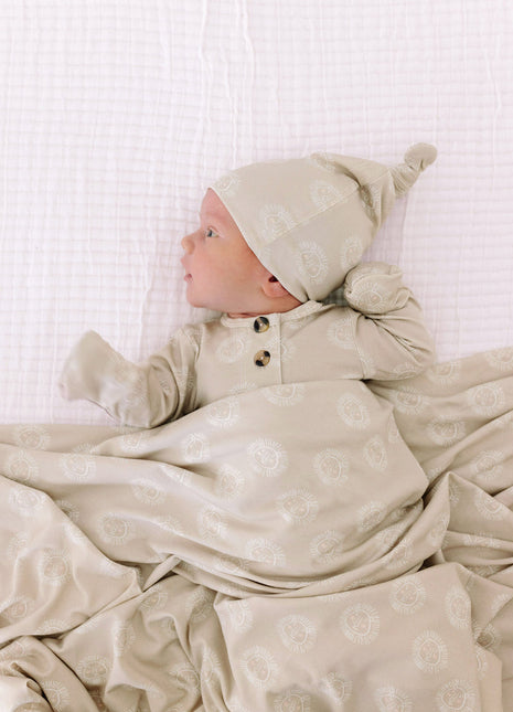 Model Wearing Lou Lou & Company Linus Top Knot Hat, knotted gown, and swaddle