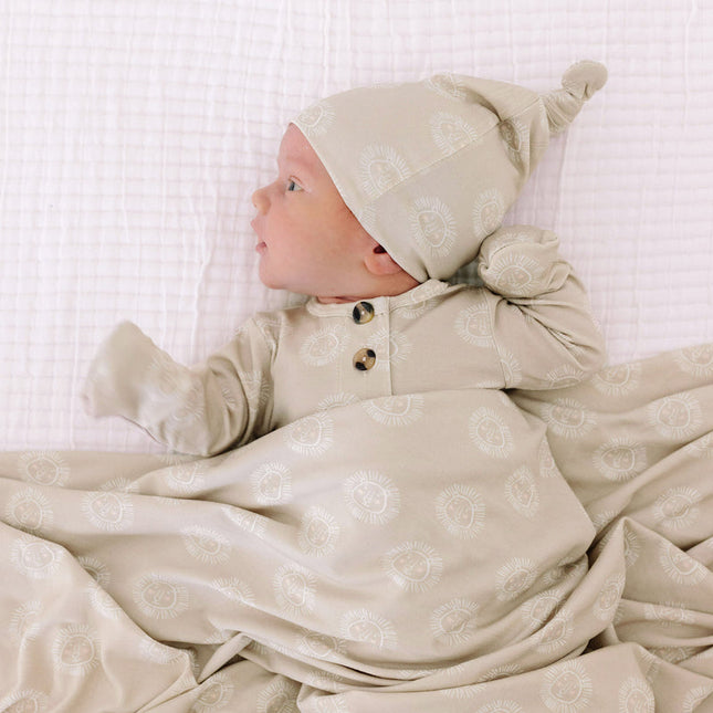 Model Wearing Lou Lou & Company Linus Top Knot Hat, knotted gown, and swaddle