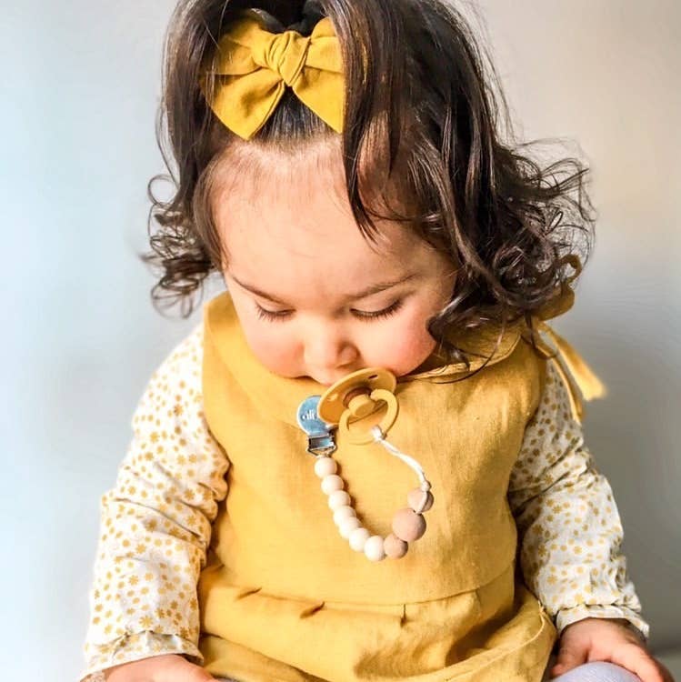Model Using Ali+Oli Silicone Pacifier Clip (White Wood)