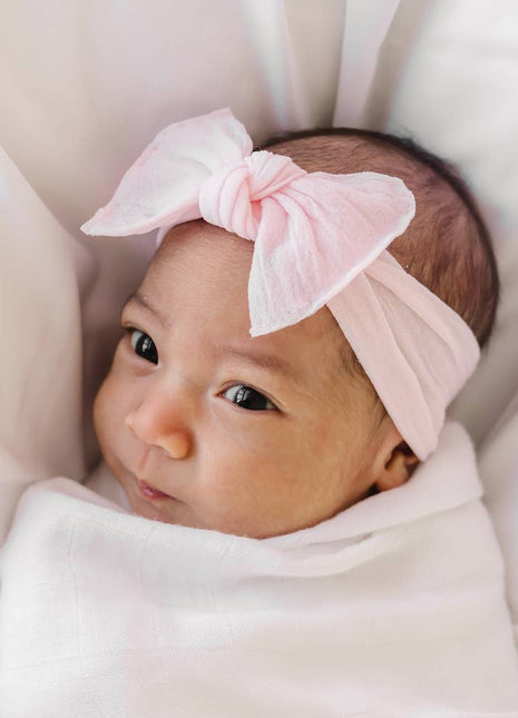 Model Wearing Baby Bling Bows Baby Bling® Itty Bitty Knot Small Soft Nylon Bow Headband - Antique Pink
