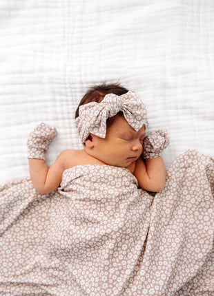 Model Wearing Lou Lou & Company Laynie Swaddle Blanket, mittens, and knot headband