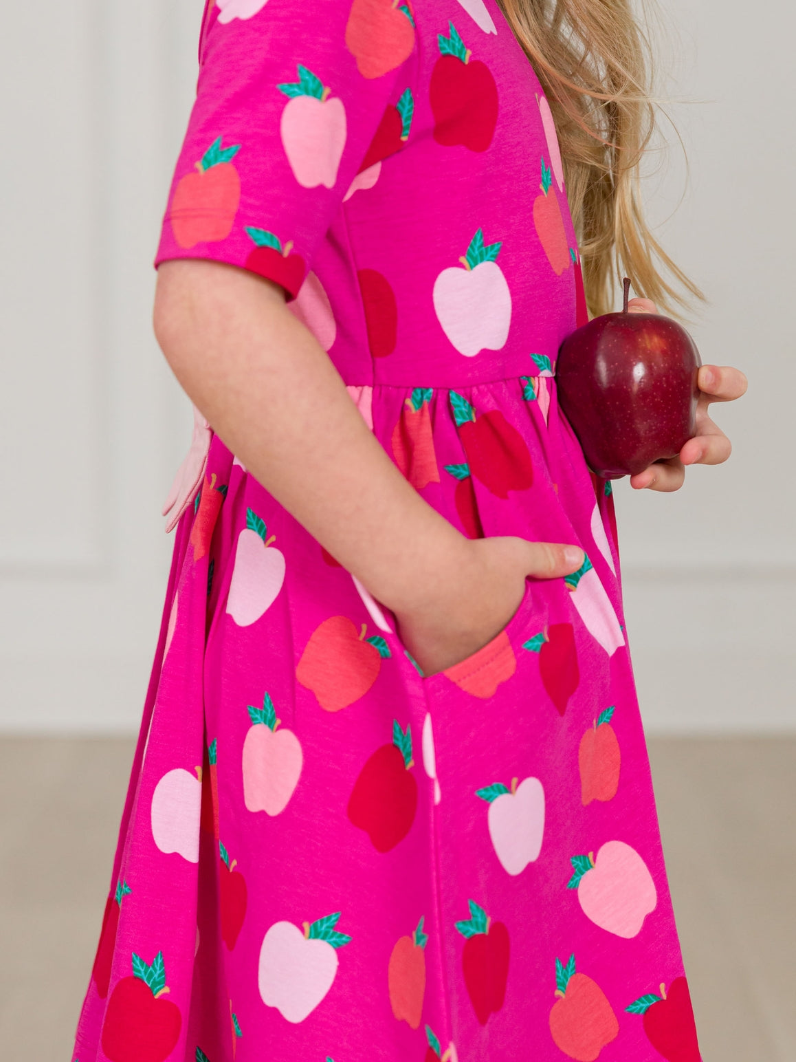 Model Wearing Rufflebutts+ Ruggedbutts Girls Apple of My Eye Short Sleeve Knit Twirl Dress